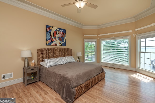 bedroom with crown molding, light hardwood / wood-style flooring, and ceiling fan