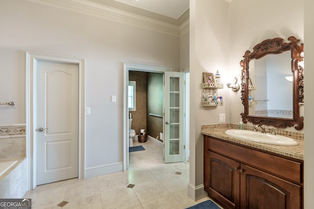 bathroom featuring toilet, ornamental molding, vanity, a tub to relax in, and tile patterned flooring