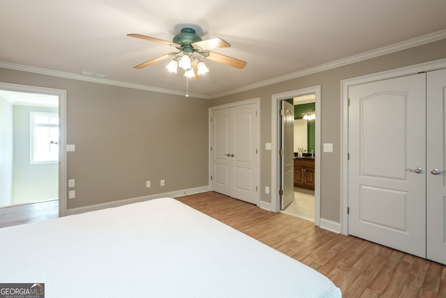 bedroom featuring crown molding, light hardwood / wood-style flooring, ensuite bathroom, and ceiling fan