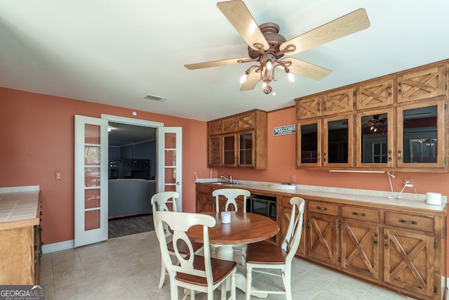 dining space with ceiling fan, sink, and light tile patterned floors