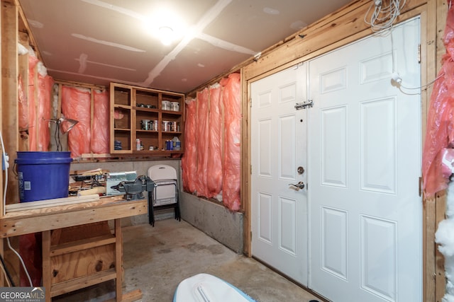 misc room with concrete flooring and a workshop area