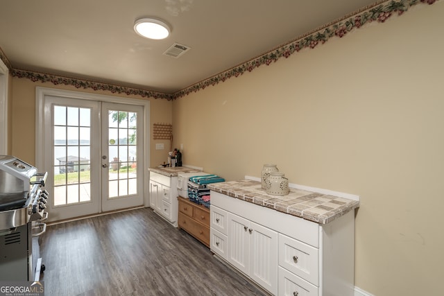 interior space with tile countertops, french doors, white cabinets, and dark wood-type flooring