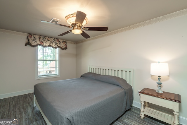 bedroom with ornamental molding, dark hardwood / wood-style floors, and ceiling fan