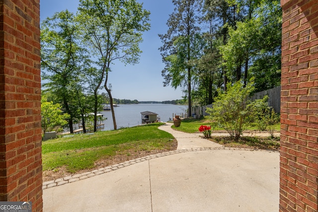 exterior space with a patio, a yard, and a water view