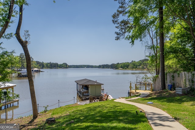 view of dock with a water view and a lawn