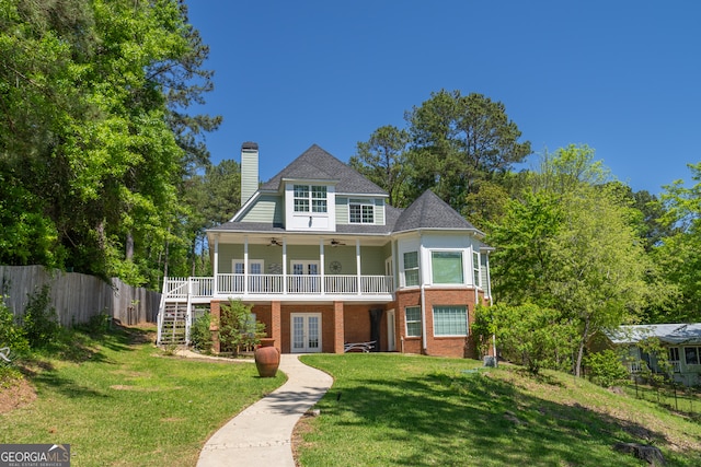 victorian home with ceiling fan and a front yard