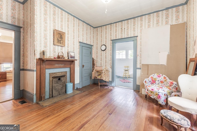 living area featuring crown molding and wood-type flooring