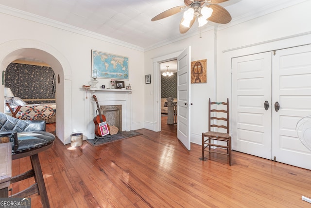 interior space featuring ceiling fan, ornamental molding, and wood-type flooring