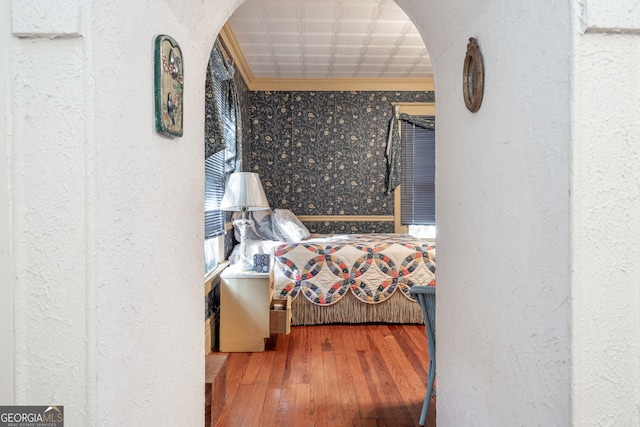 bedroom with crown molding and hardwood / wood-style flooring