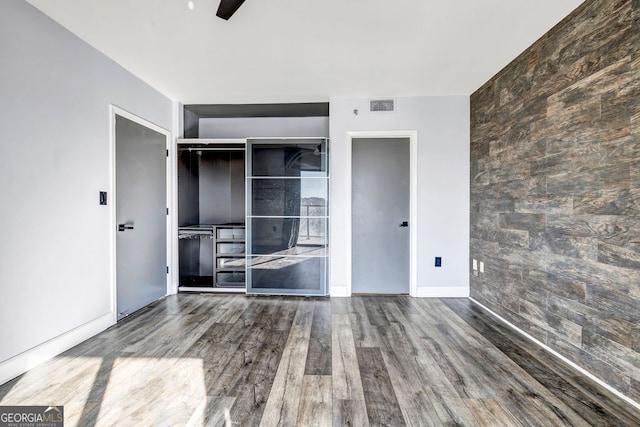 unfurnished bedroom featuring a closet, ceiling fan, and wood-type flooring