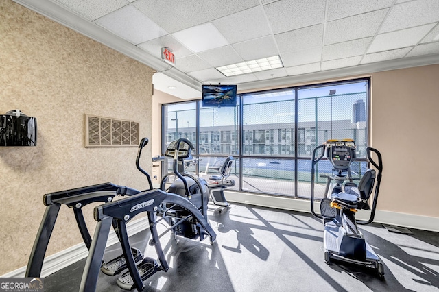 gym featuring crown molding and a drop ceiling