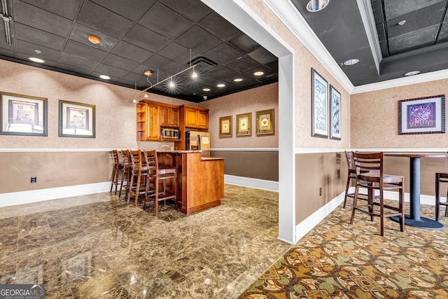 bar featuring crown molding, appliances with stainless steel finishes, and a paneled ceiling