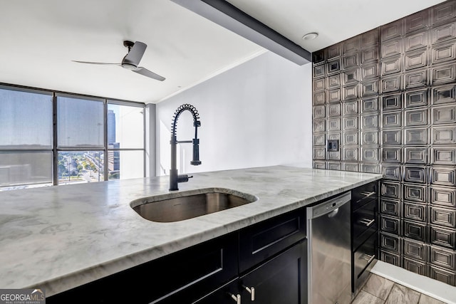 kitchen with sink, crown molding, stainless steel dishwasher, tile walls, and light stone counters