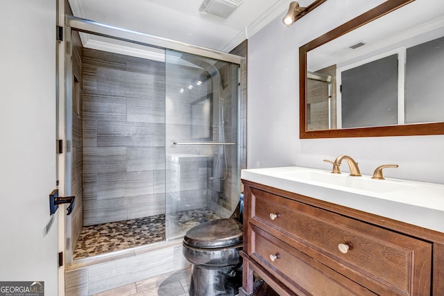 bathroom with vanity, ornamental molding, toilet, and a shower with door