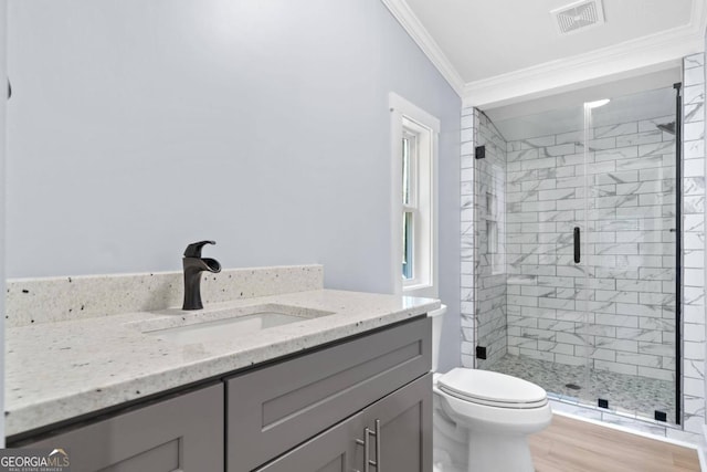 bathroom featuring hardwood / wood-style flooring, toilet, ornamental molding, vanity, and an enclosed shower