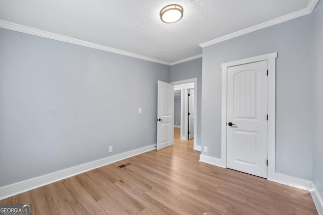 unfurnished bedroom with a closet, crown molding, a textured ceiling, and light hardwood / wood-style floors