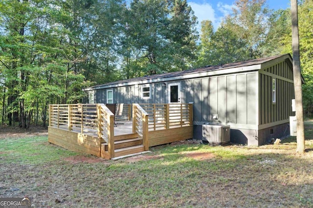 rear view of property featuring a wooden deck and central AC unit