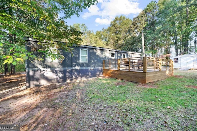 back of house with a wooden deck and a yard