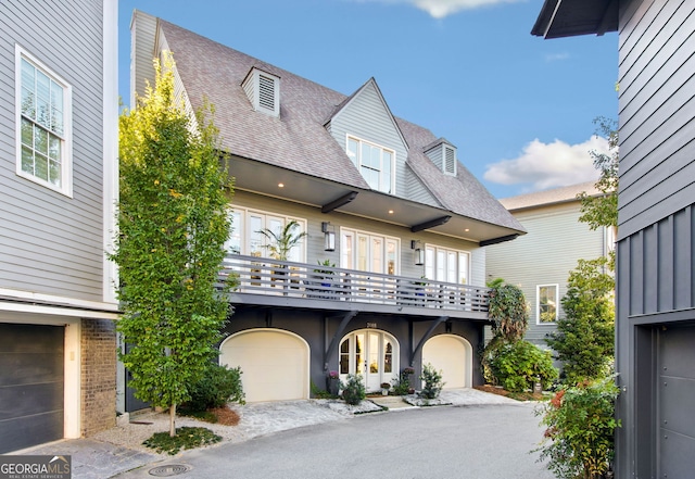 view of front of property featuring a garage and a balcony