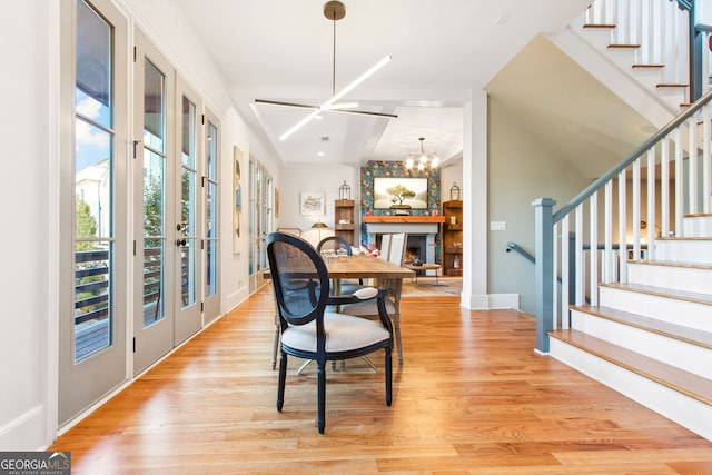 dining room featuring french doors, light hardwood / wood-style floors, and a chandelier