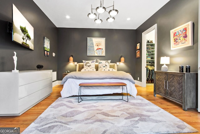 bedroom featuring a chandelier and light hardwood / wood-style flooring