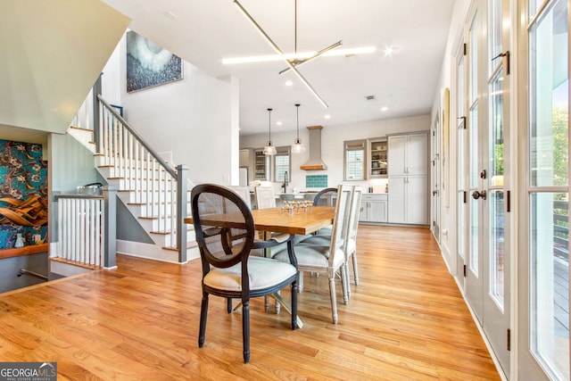 dining area with light hardwood / wood-style floors, a chandelier, and plenty of natural light