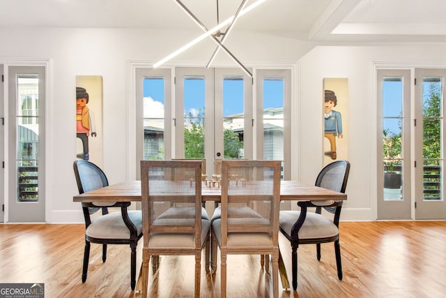 dining area featuring a chandelier, light wood-type flooring, and french doors