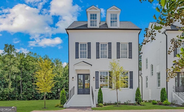 view of front facade with a front yard and french doors