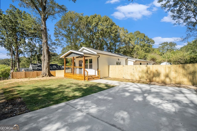 view of front of house featuring a patio area, a front yard, and a wooden deck