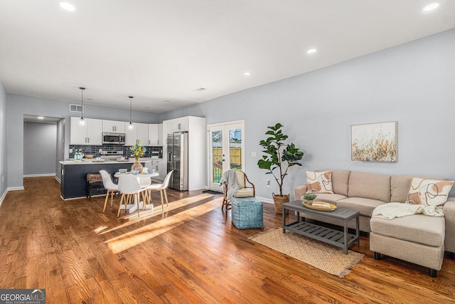 living area with recessed lighting, visible vents, baseboards, and dark wood finished floors