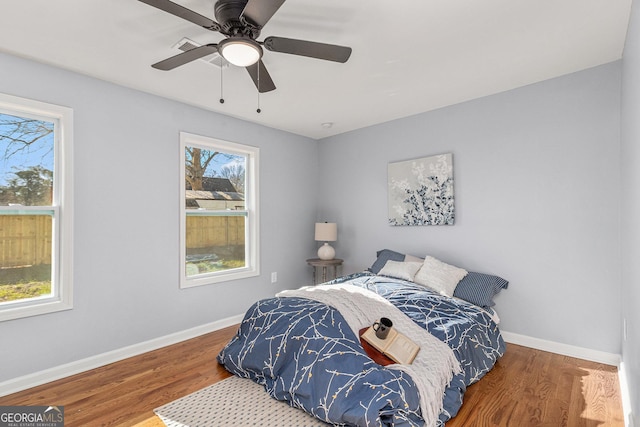 bedroom with ceiling fan, baseboards, and wood finished floors