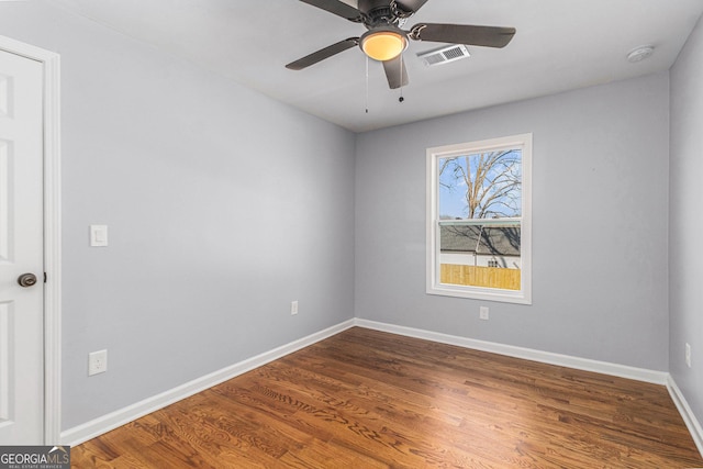 spare room with visible vents, baseboards, ceiling fan, and wood finished floors