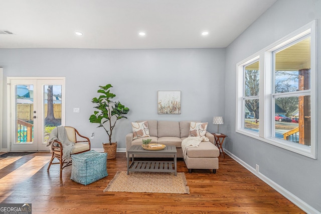 living room featuring wood finished floors, baseboards, and a wealth of natural light