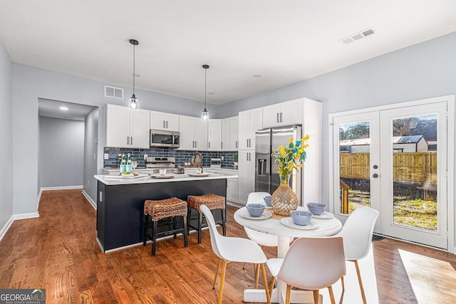 dining room with visible vents, french doors, baseboards, and wood finished floors