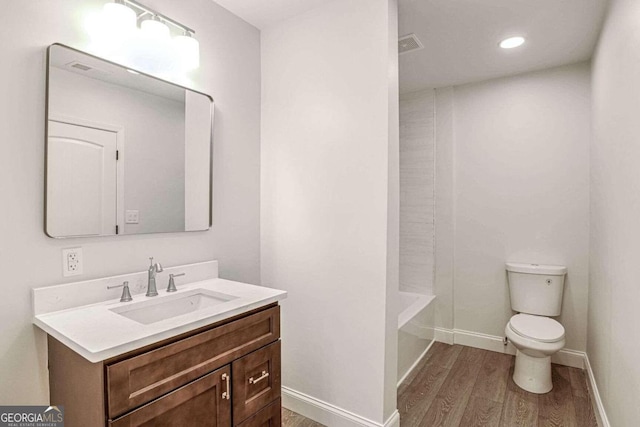 bathroom with hardwood / wood-style floors, vanity, and toilet