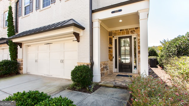 entrance to property featuring central AC and a garage