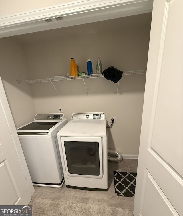 laundry room with washing machine and clothes dryer and light carpet