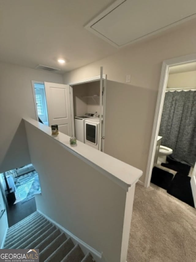 stairway with washer and dryer and carpet flooring