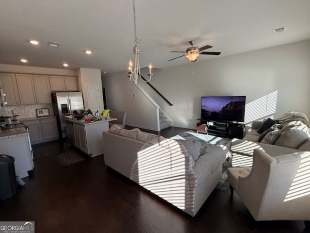 living room featuring dark hardwood / wood-style floors and ceiling fan with notable chandelier