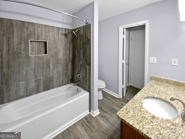 full bathroom with vanity, toilet, tiled shower / bath, and hardwood / wood-style floors