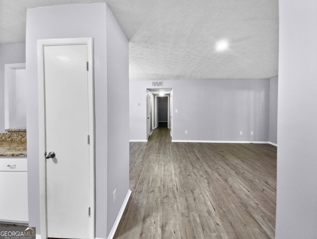 interior space with a textured ceiling and wood-type flooring