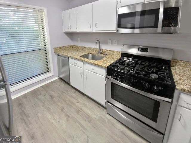 kitchen featuring sink, appliances with stainless steel finishes, white cabinets, and light hardwood / wood-style floors