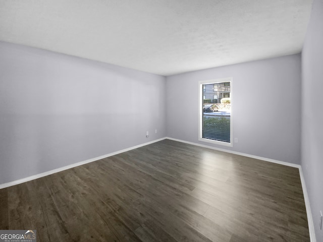 unfurnished room with dark hardwood / wood-style flooring