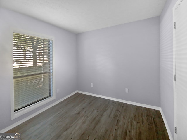 unfurnished room featuring dark wood-type flooring