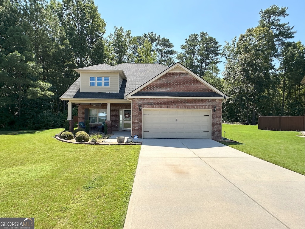 craftsman house with a front yard, covered porch, and a garage