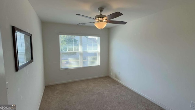 carpeted spare room featuring ceiling fan