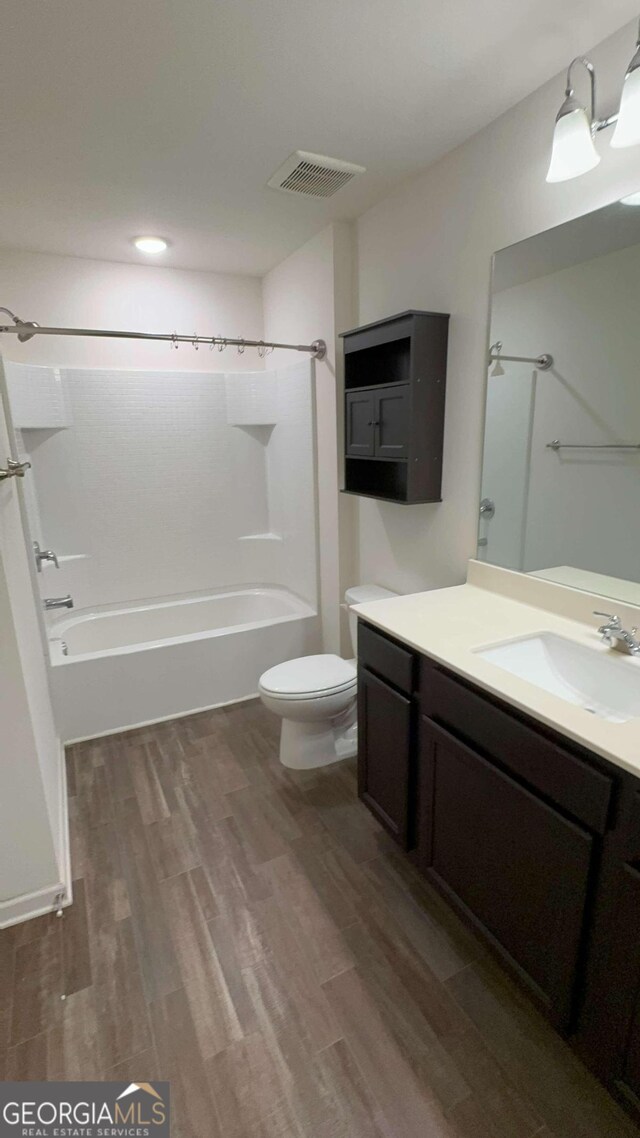 full bathroom featuring bathtub / shower combination, vanity, wood-type flooring, and toilet