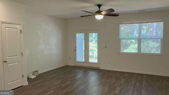 unfurnished room with dark hardwood / wood-style floors, ceiling fan, and a wealth of natural light