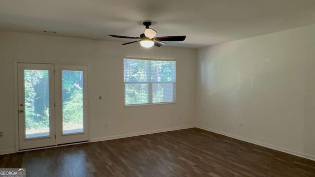 empty room with dark wood-type flooring, ceiling fan, and plenty of natural light