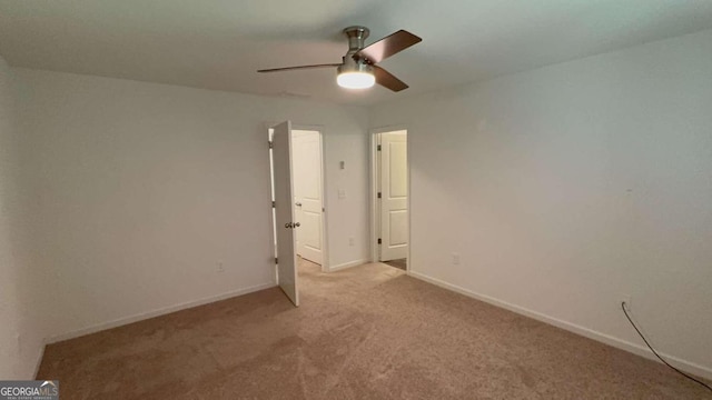 carpeted spare room with ceiling fan